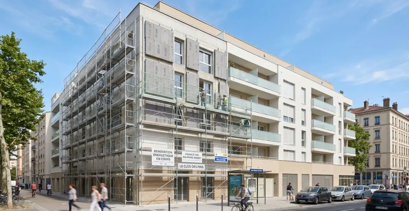 Bâtiment résidentiel français contemporain en cours de rénovation énergétique avec échafaudage léger et isolation de façade visible, contexte urbain moderne, ciel dégagé